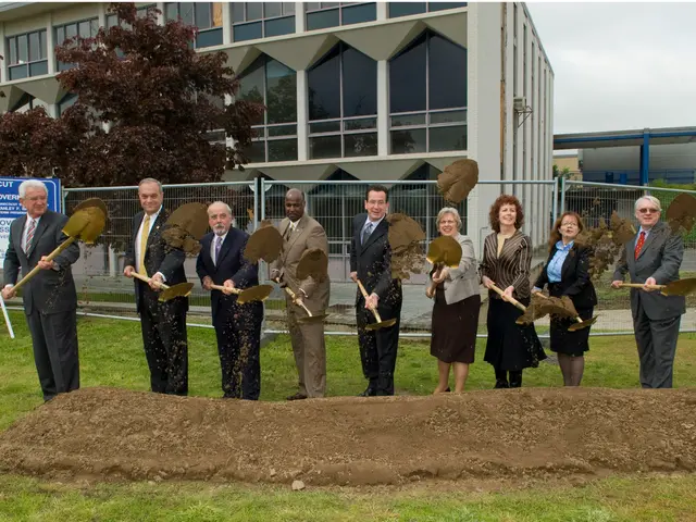 In this image there are few people wearing coat. They all are holding shovel. They are putting mud...