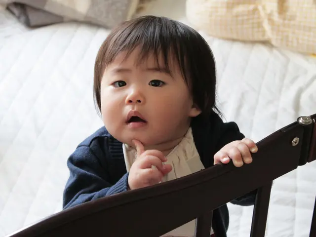 In this image I can see a child and a bed.