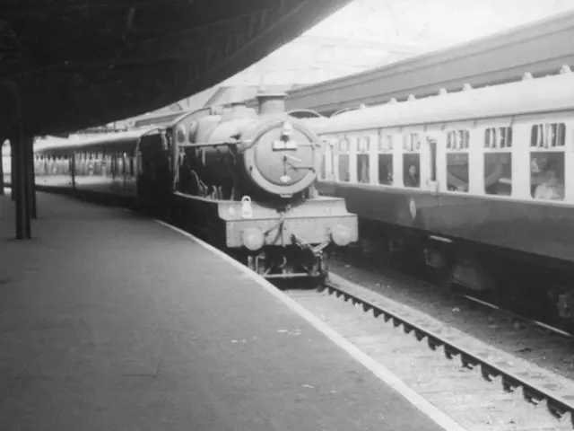 This is the black and white image, on the left, there are two trains moving on the track. On the...